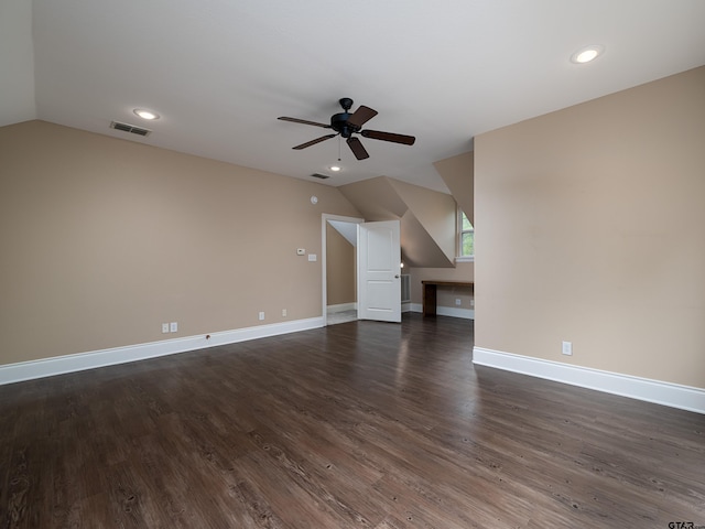 unfurnished living room featuring vaulted ceiling, a ceiling fan, baseboards, visible vents, and dark wood-style flooring