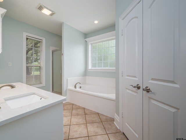 bathroom featuring a bath, visible vents, tile patterned floors, a sink, and a stall shower
