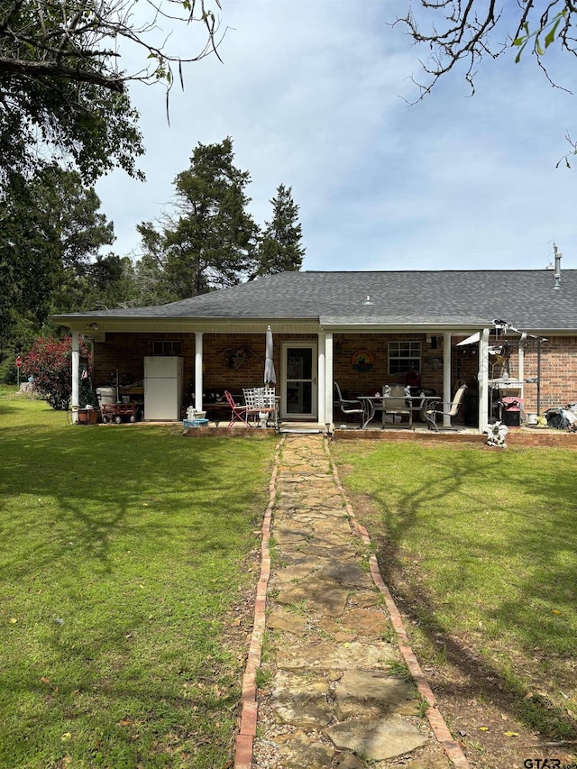 rear view of house with a patio area and a lawn