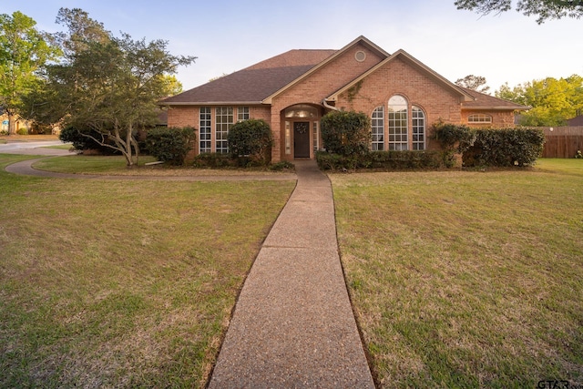 1621 Cimmarron Trl, Tyler, TX 75703 - view of front of house with a front yard, fence, and brick siding