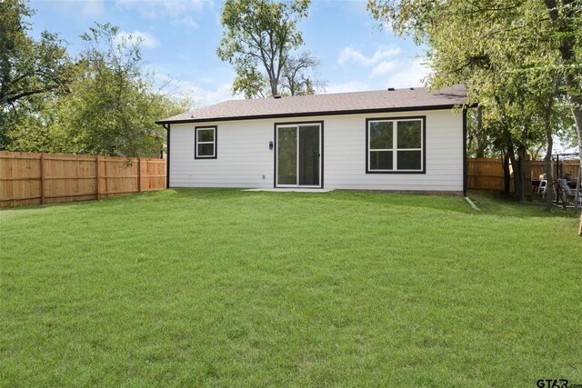 rear view of house featuring a yard