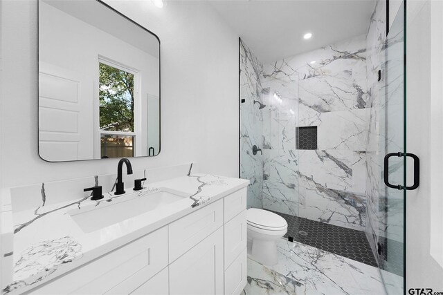 bathroom featuring a shower with shower door, vanity, and toilet