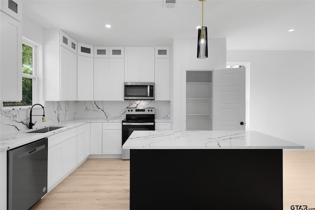 kitchen featuring decorative backsplash, appliances with stainless steel finishes, sink, and a kitchen island