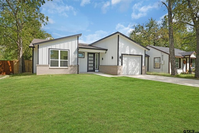 view of front of home with a garage and a front lawn