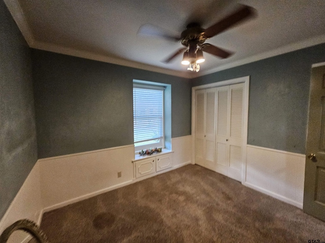 236 La Jolla Dr, Athens, TX 75751 - unfurnished bedroom featuring ornamental molding, dark carpet, a closet, a ceiling fan, and wainscoting