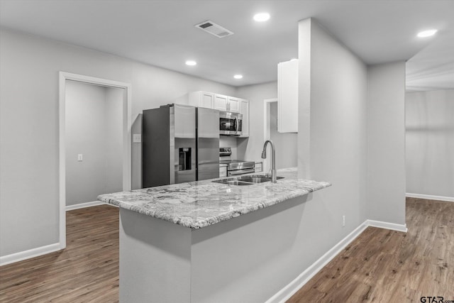 1004 Bunny Rabbit Rd, Athens, TX 75751 - kitchen featuring stainless steel appliances, white cabinetry, a peninsula, wood finished floors, and recessed lighting