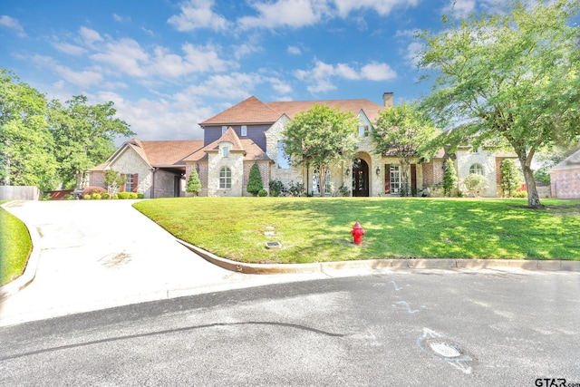 6805 Castle Pines Ct, Tyler, TX 75703 - view of front of house with a front lawn, a chimney, and brick siding