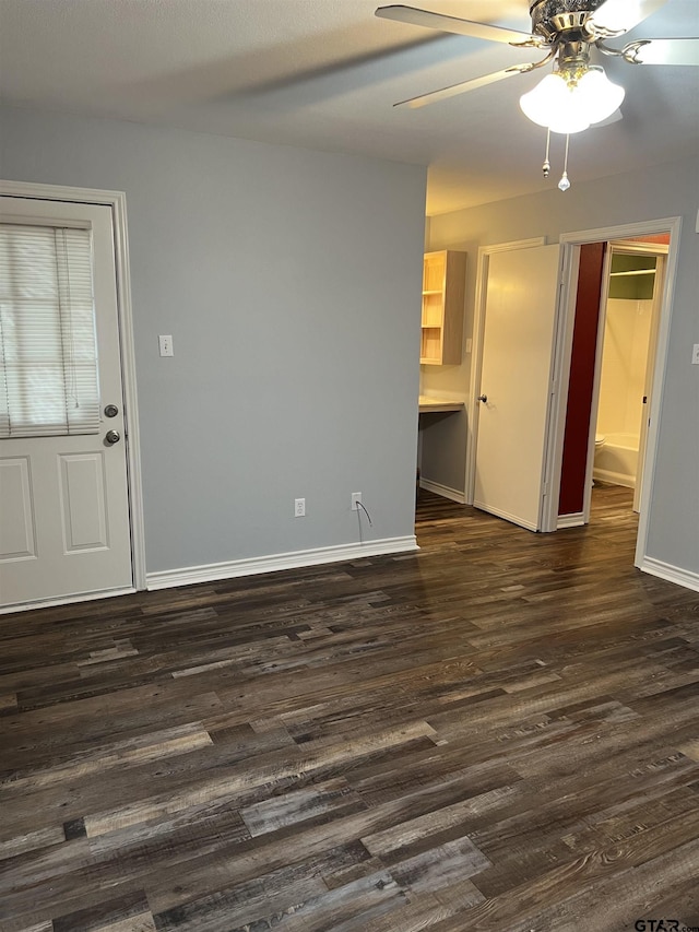 spare room featuring dark wood-type flooring and ceiling fan