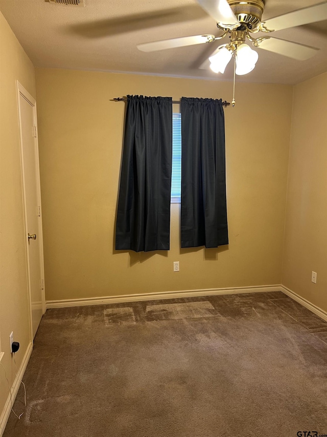 carpeted spare room with ceiling fan