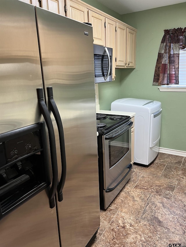 interior space with stainless steel appliances, washing machine and dryer, and cream cabinetry