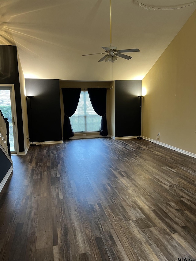 empty room featuring dark hardwood / wood-style flooring, plenty of natural light, and vaulted ceiling