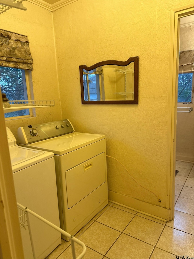 clothes washing area featuring separate washer and dryer and light tile patterned flooring