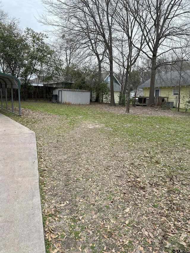 view of yard with a carport and a storage shed