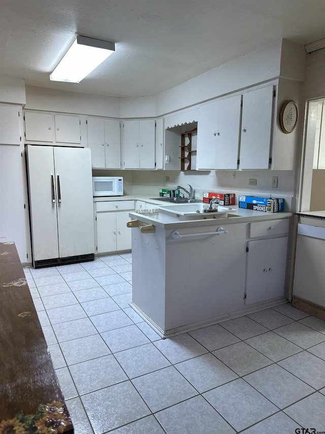 kitchen featuring white cabinets, light tile patterned floors, white appliances, and sink