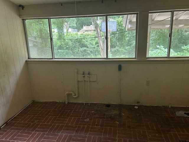 524 E San Antonio St, Alto, TX 75925 - spare room with healthy amount of natural light, brick floors, and wood walls