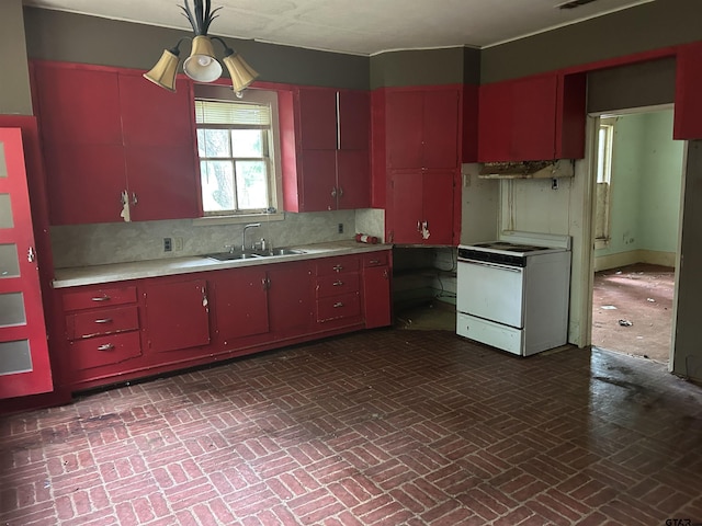 524 E San Antonio St, Alto, TX 75925 - kitchen featuring electric range, red cabinets, a sink, brick patterned floors, and light countertops