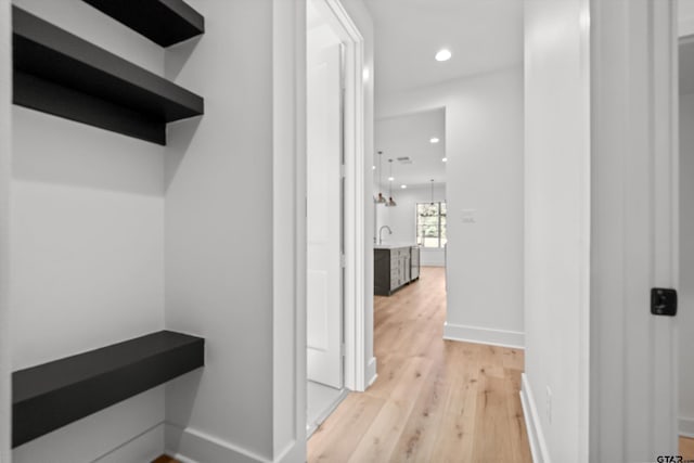 hall with sink and light hardwood / wood-style flooring