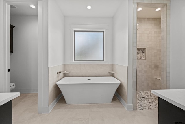 full bathroom featuring vanity, tile walls, plus walk in shower, tile patterned flooring, and toilet