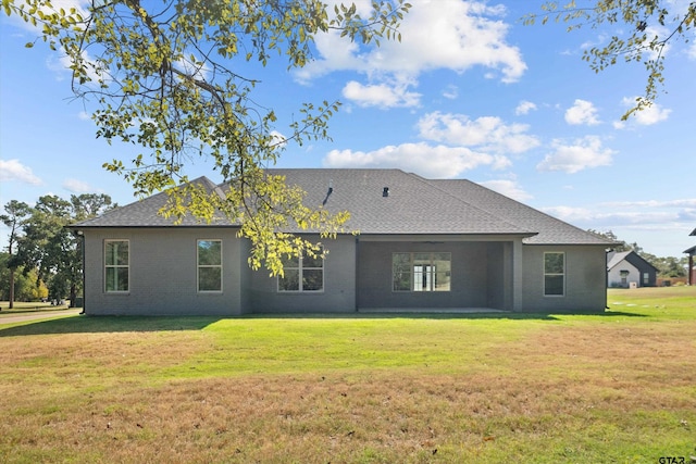 rear view of property featuring a yard