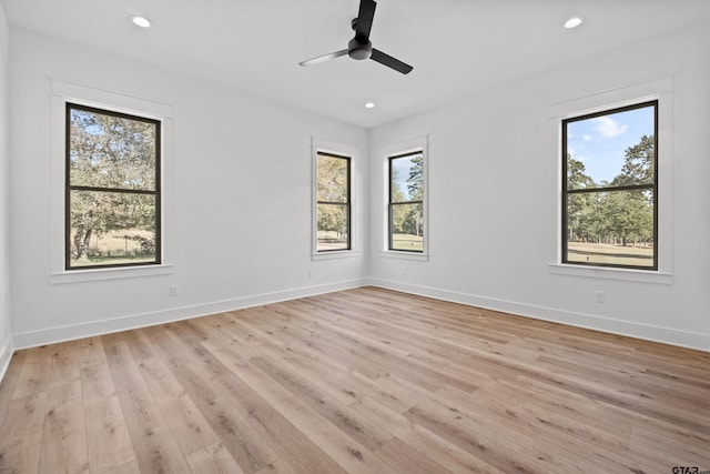 empty room with ceiling fan and light hardwood / wood-style floors