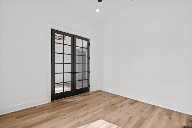 empty room featuring french doors and light hardwood / wood-style floors