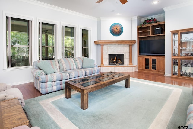 11831 Smallwood Dr, Flint, TX 75762 - living area featuring ceiling fan, wood finished floors, crown molding, a tile fireplace, and baseboards