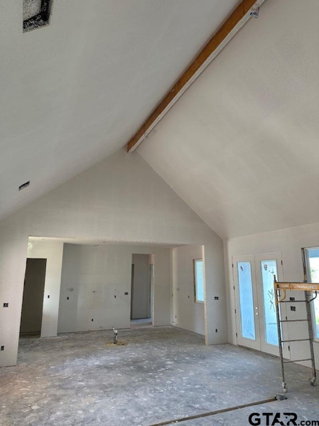 unfurnished living room featuring high vaulted ceiling and beamed ceiling