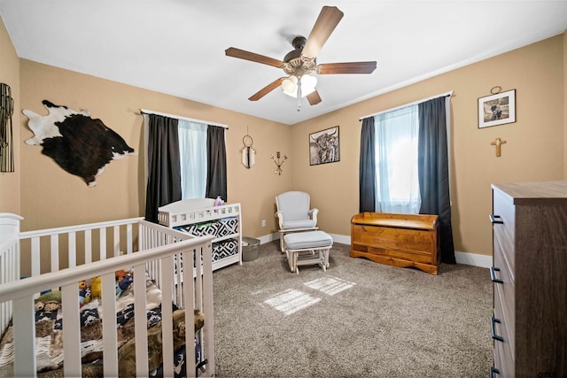 bedroom featuring a crib, carpet, and ceiling fan