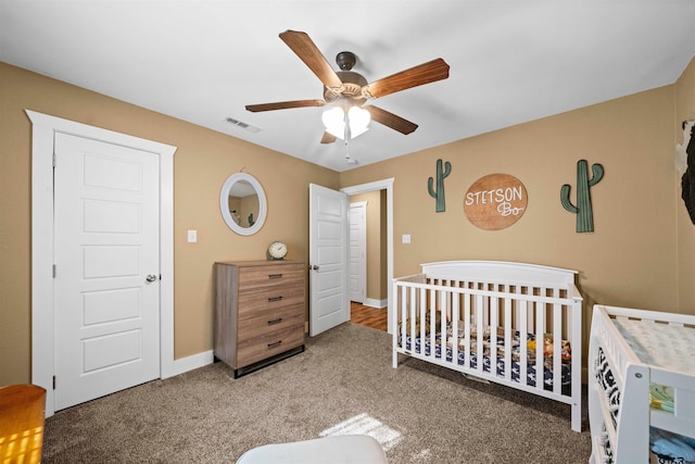 bedroom featuring ceiling fan, a crib, and carpet floors