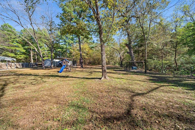 view of yard featuring a playground and a storage unit