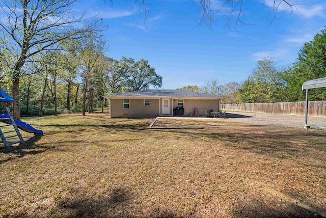 rear view of house with a lawn and a playground