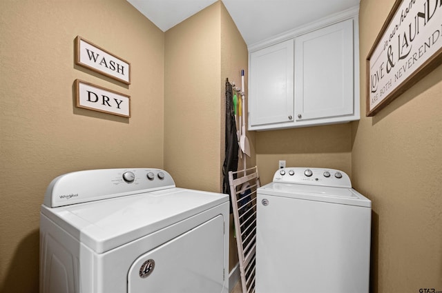 washroom featuring washer and dryer and cabinets