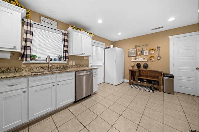 kitchen featuring light stone counters, sink, white cabinets, and stainless steel dishwasher