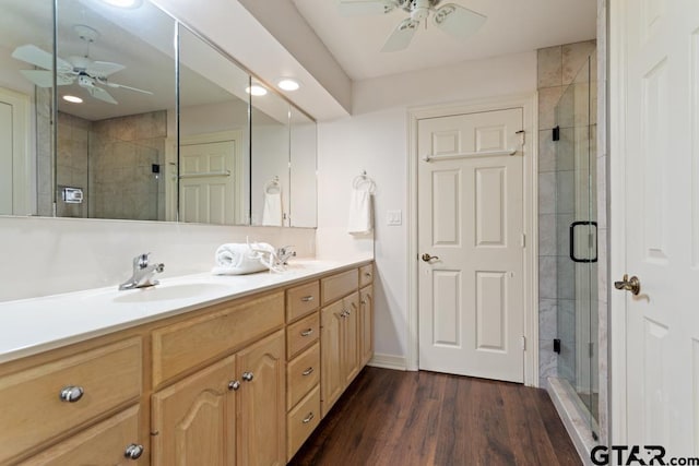 bathroom with vanity, hardwood / wood-style flooring, walk in shower, and ceiling fan