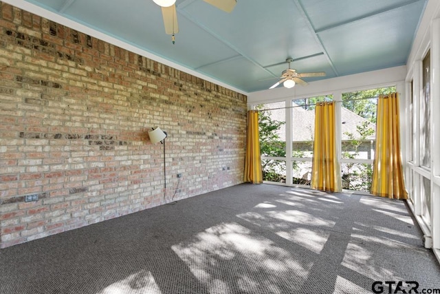 unfurnished sunroom with ceiling fan