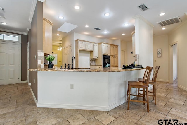 kitchen with kitchen peninsula, decorative backsplash, and sink