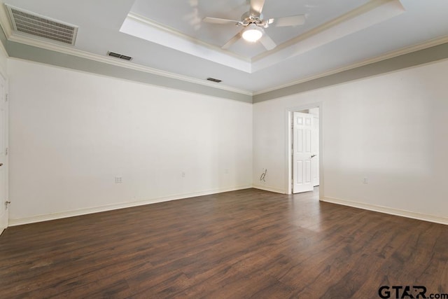 empty room featuring a tray ceiling, crown molding, ceiling fan, and dark hardwood / wood-style floors