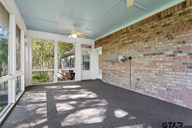 unfurnished sunroom with ceiling fan