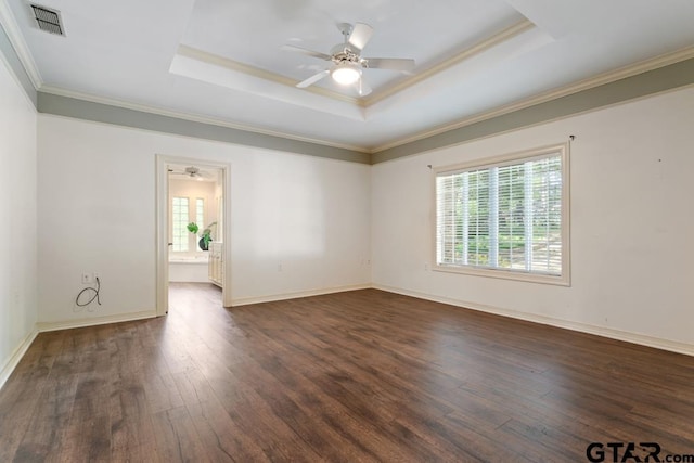 unfurnished room featuring ceiling fan, a raised ceiling, ornamental molding, and dark wood-type flooring