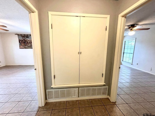 interior space with ceiling fan and a textured ceiling