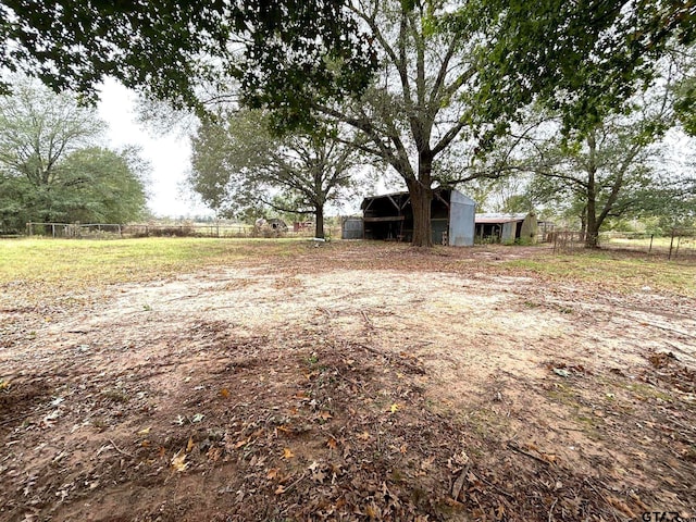 view of yard with an outbuilding and a rural view