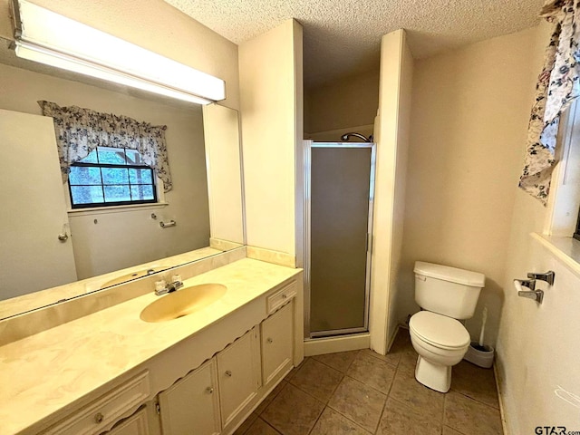 bathroom with a shower with door, vanity, a textured ceiling, and toilet