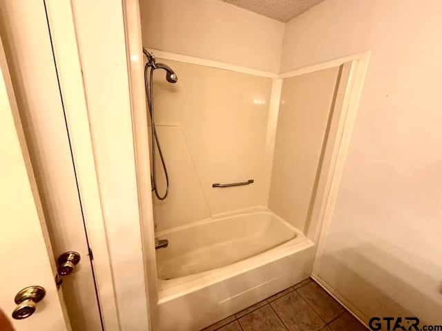 bathroom with  shower combination, tile patterned flooring, and a textured ceiling