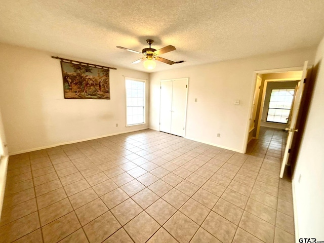 tiled spare room featuring ceiling fan and a textured ceiling