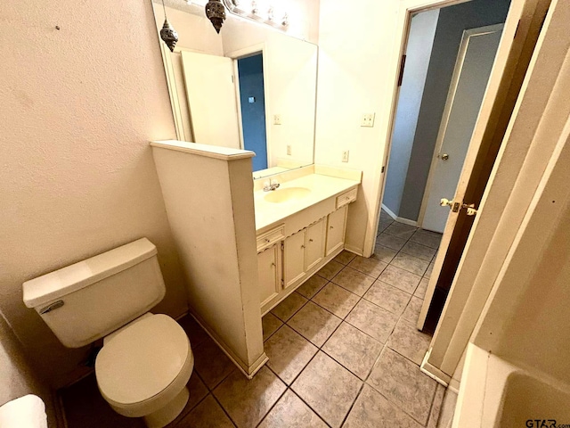 bathroom with tile patterned flooring, vanity, and toilet