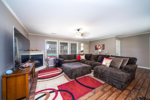 living room featuring dark wood-type flooring, ceiling fan, and ornamental molding