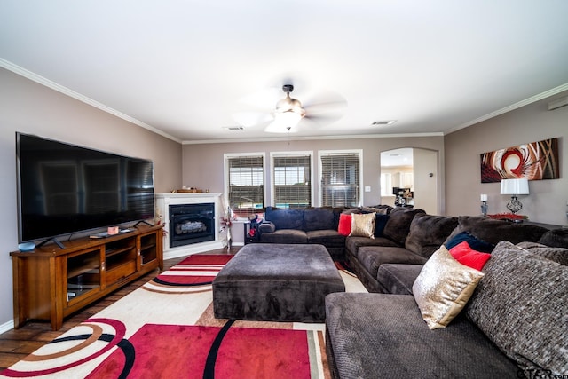 living room featuring wood-type flooring, ceiling fan, and ornamental molding