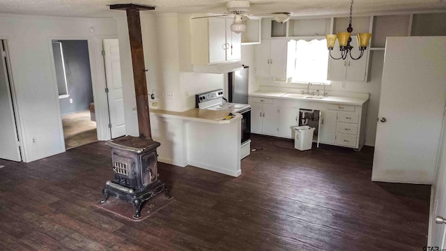 kitchen with white cabinets, hanging light fixtures, white electric stove, and a wood stove