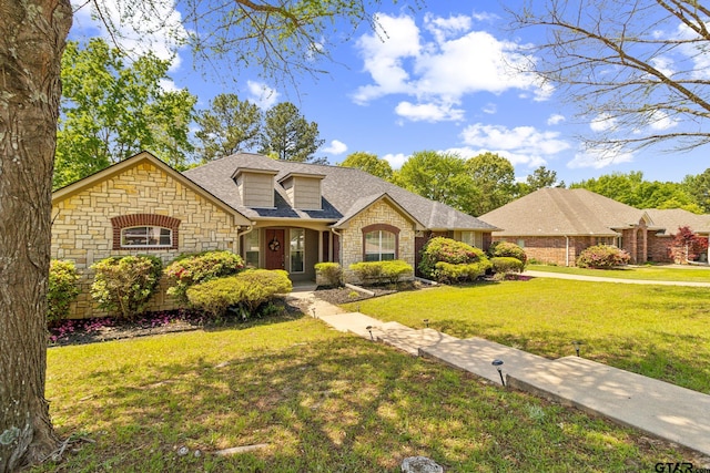 view of front of house featuring roof with shingles, stone siding, and a front lawn