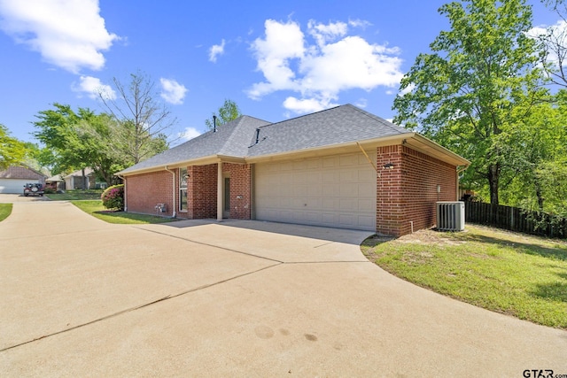 view of side of home featuring a garage, brick siding, fence, and concrete driveway